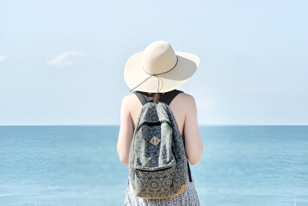 Fille avec un chapeau à un permanent du sac à dos
